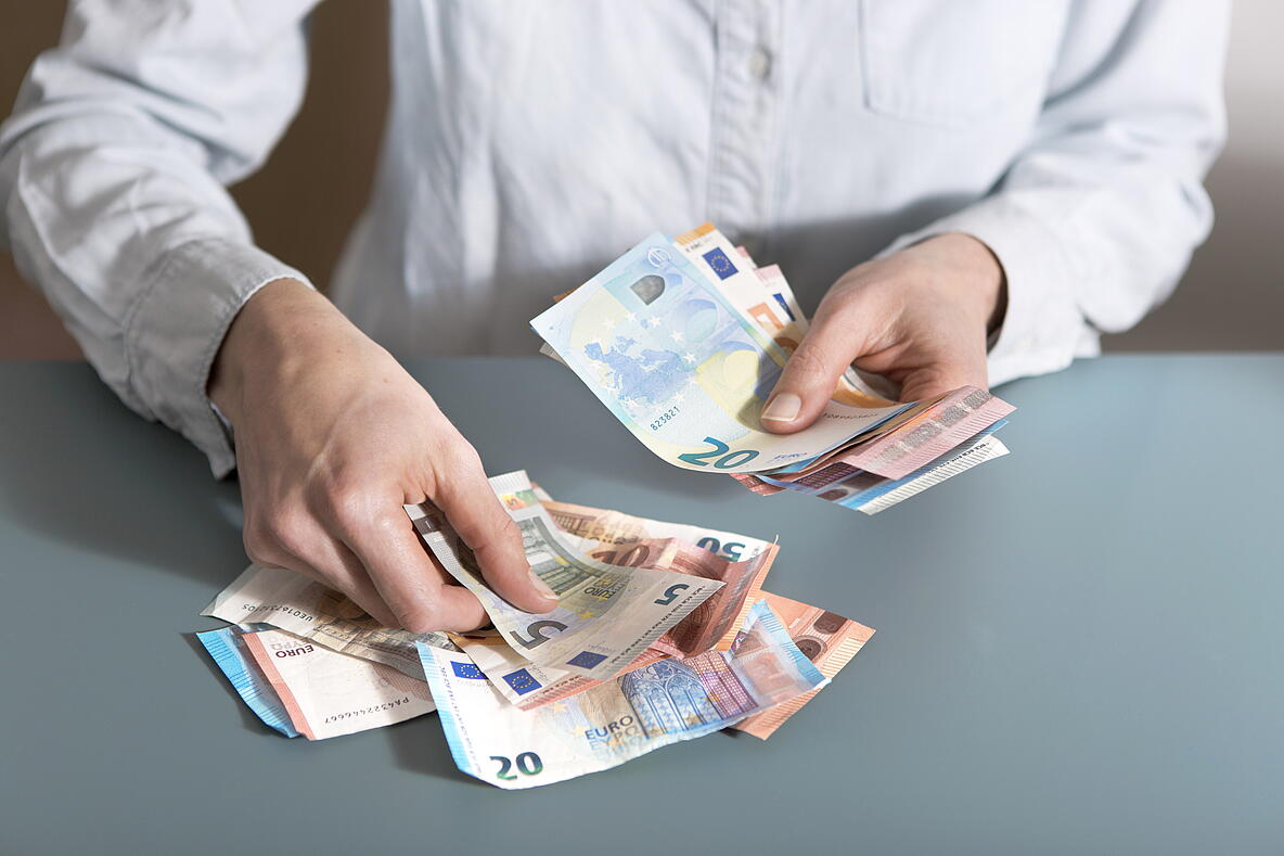 Person die Euroscheine zählt