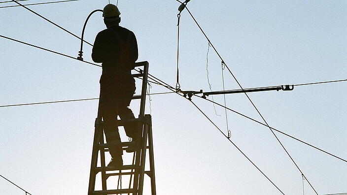 Person die an Stromnetz arbeitet