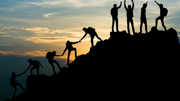 Gruppe an Menschen die einen Berg besteigen