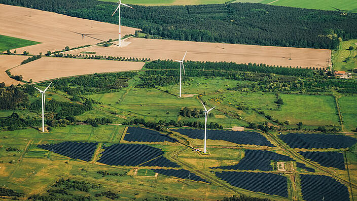 Landschaft von oben mit Windrädern und Solaranlagen