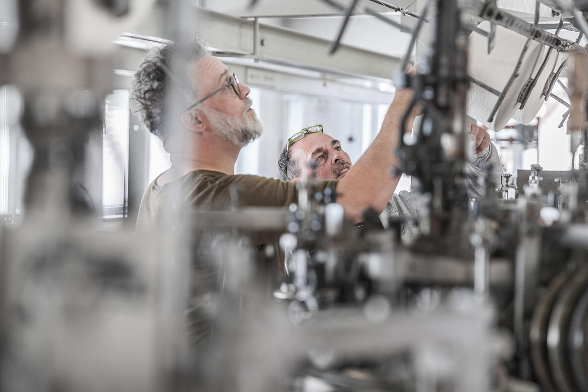 Zwei Personen die eine Maschine inspizieren