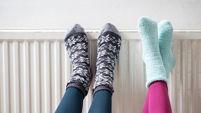 Füße in Socken an einer Heizung