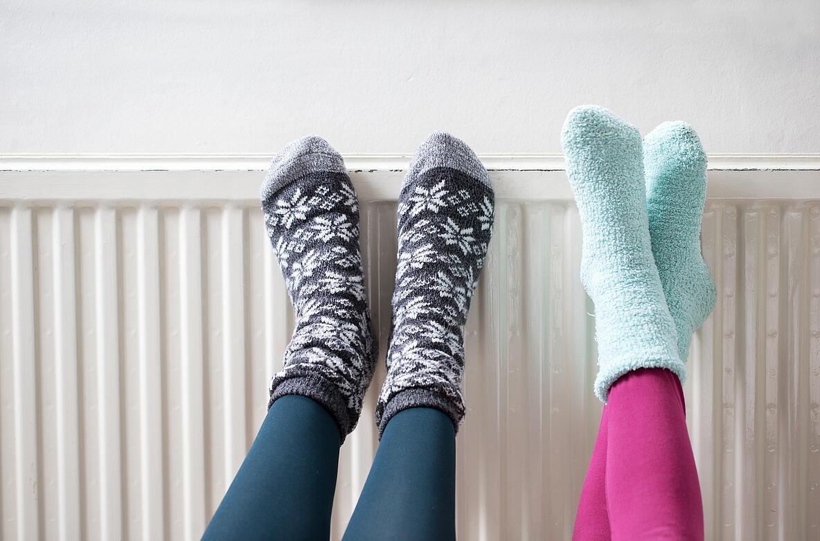 Füße in Socken an einer Heizung
