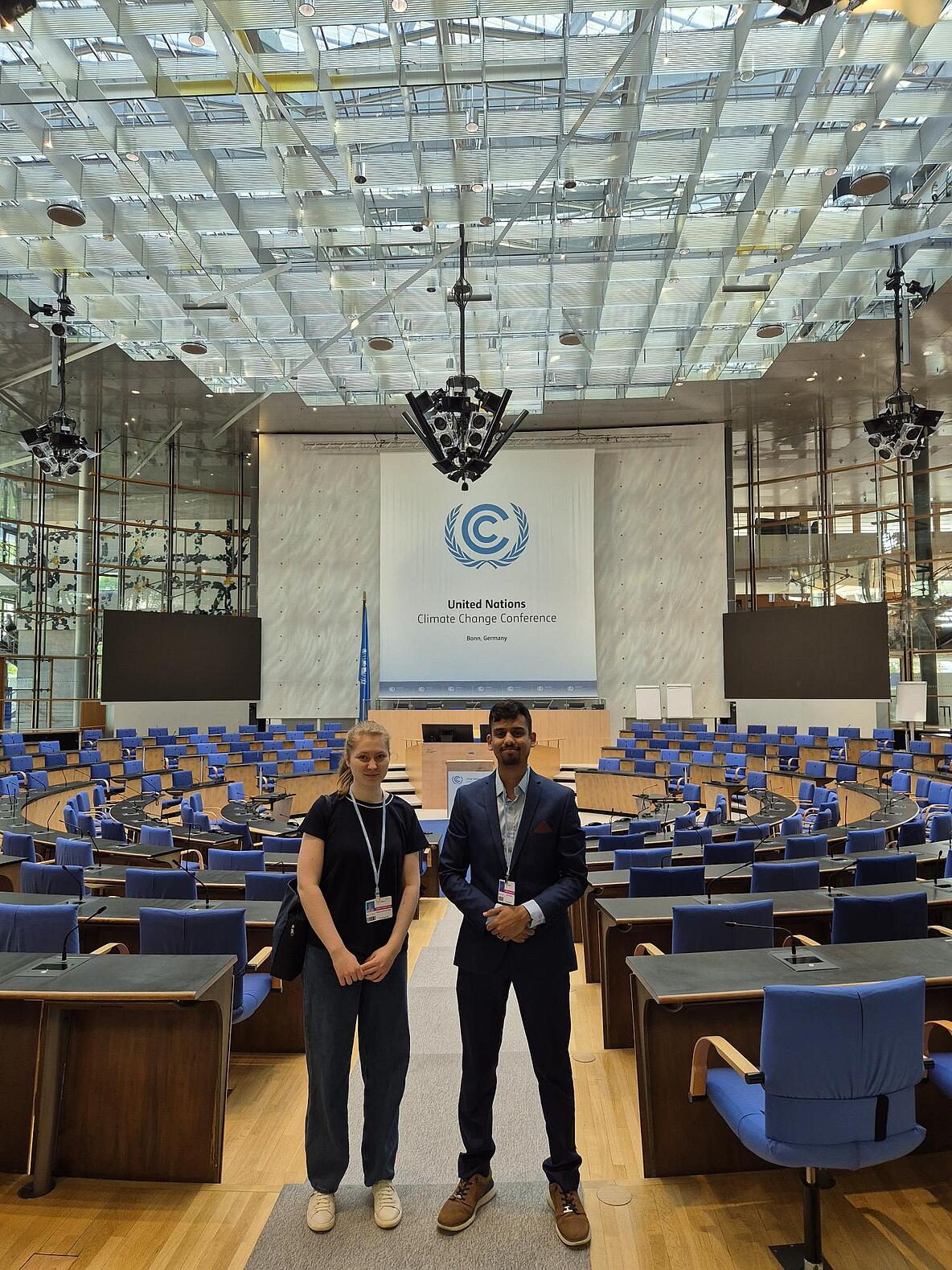 FÖJler*innen Marina Motz und Dhruv Dhabe im Verhandlungssaal bei der SB62 in Bonn
