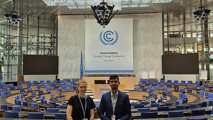 FÖJler*innen Marina Motz und Dhruv Dhabe im Verhandlungssaal bei der SB62 in Bonn