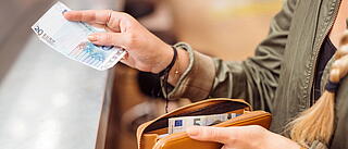 Ausschnitt einer Hand die mit Euroscheinen bezahlt