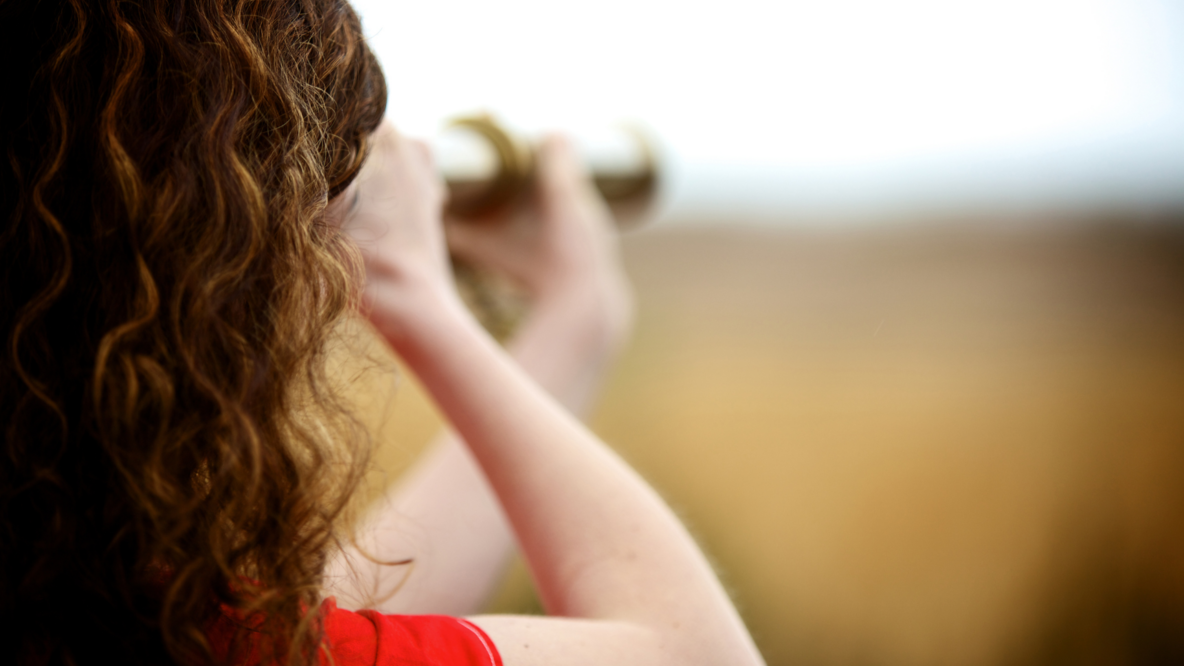 Person die durch Fernrohr schaut