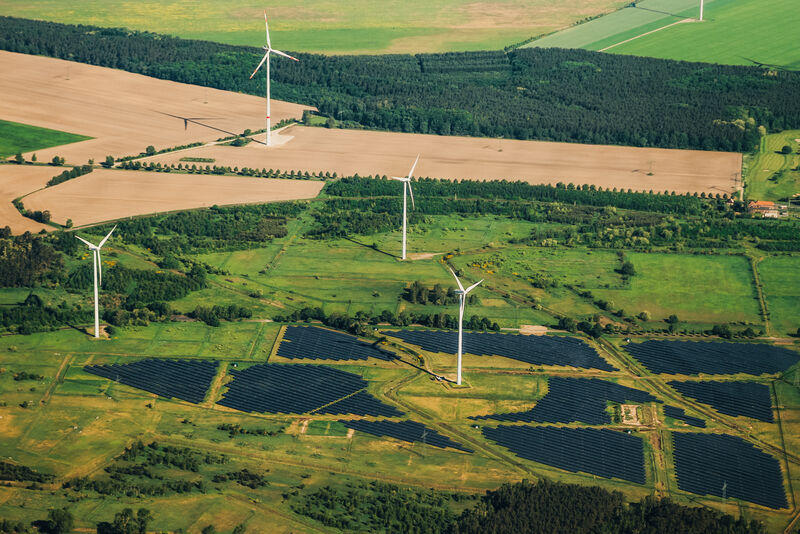 Landschaft von oben mit Windrädern und Solaranlagen